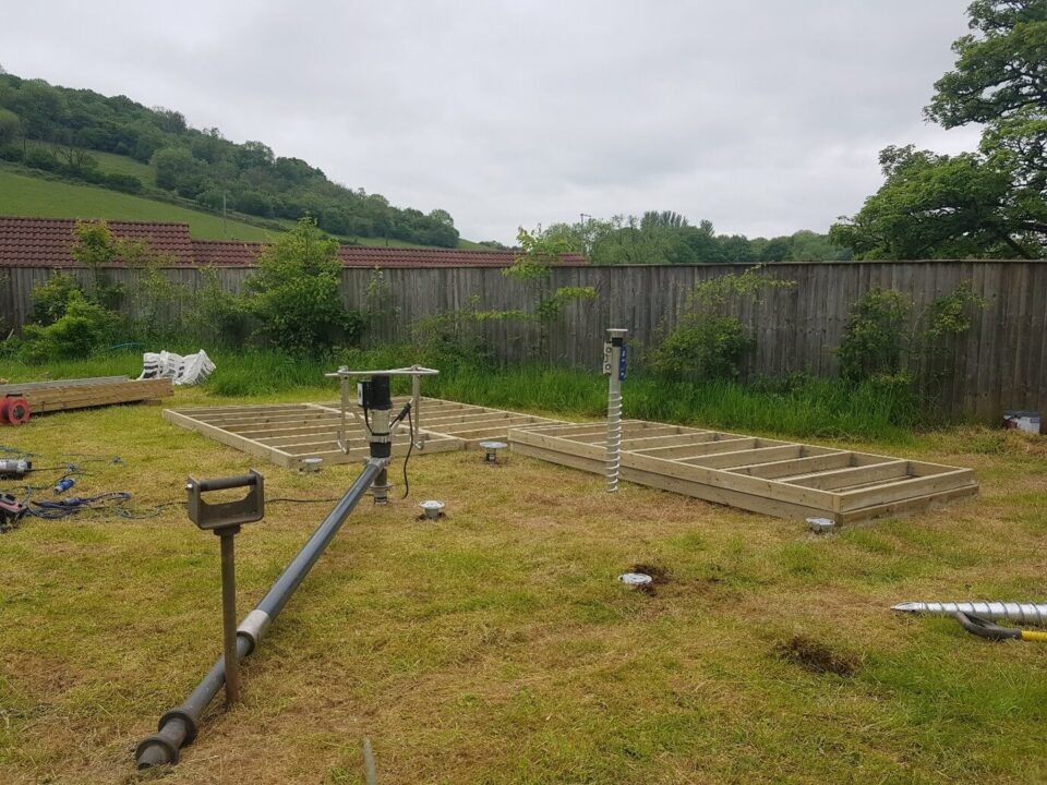 Garden studio foundations being installed using large ground screws